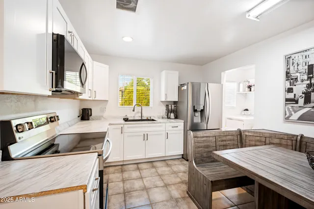 a kitchen with a stove a sink a refrigerator and cabinets
