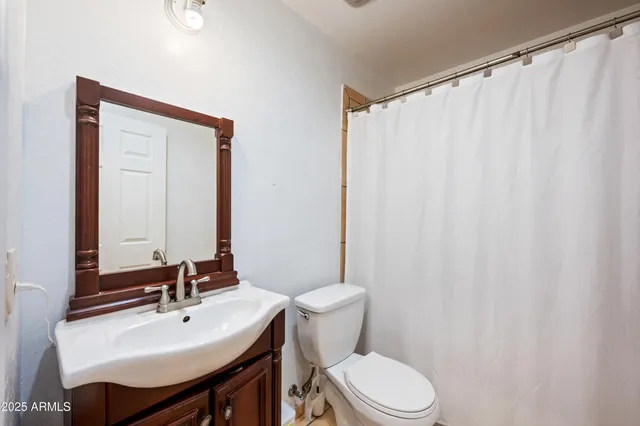 a bathroom with a sink a toilet and a mirror