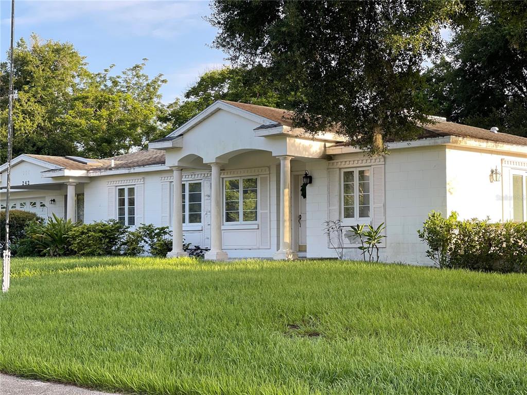 a front view of a house with a garden and yard