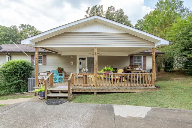 a view of a house with a yard and deck area next to a yard