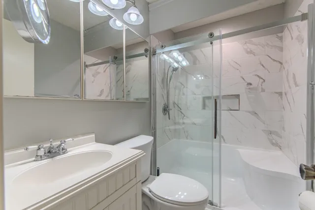 a bathroom with a sink a toilet and shower