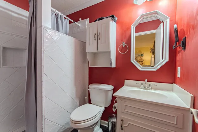 a bathroom with a toilet a sink and a mirror