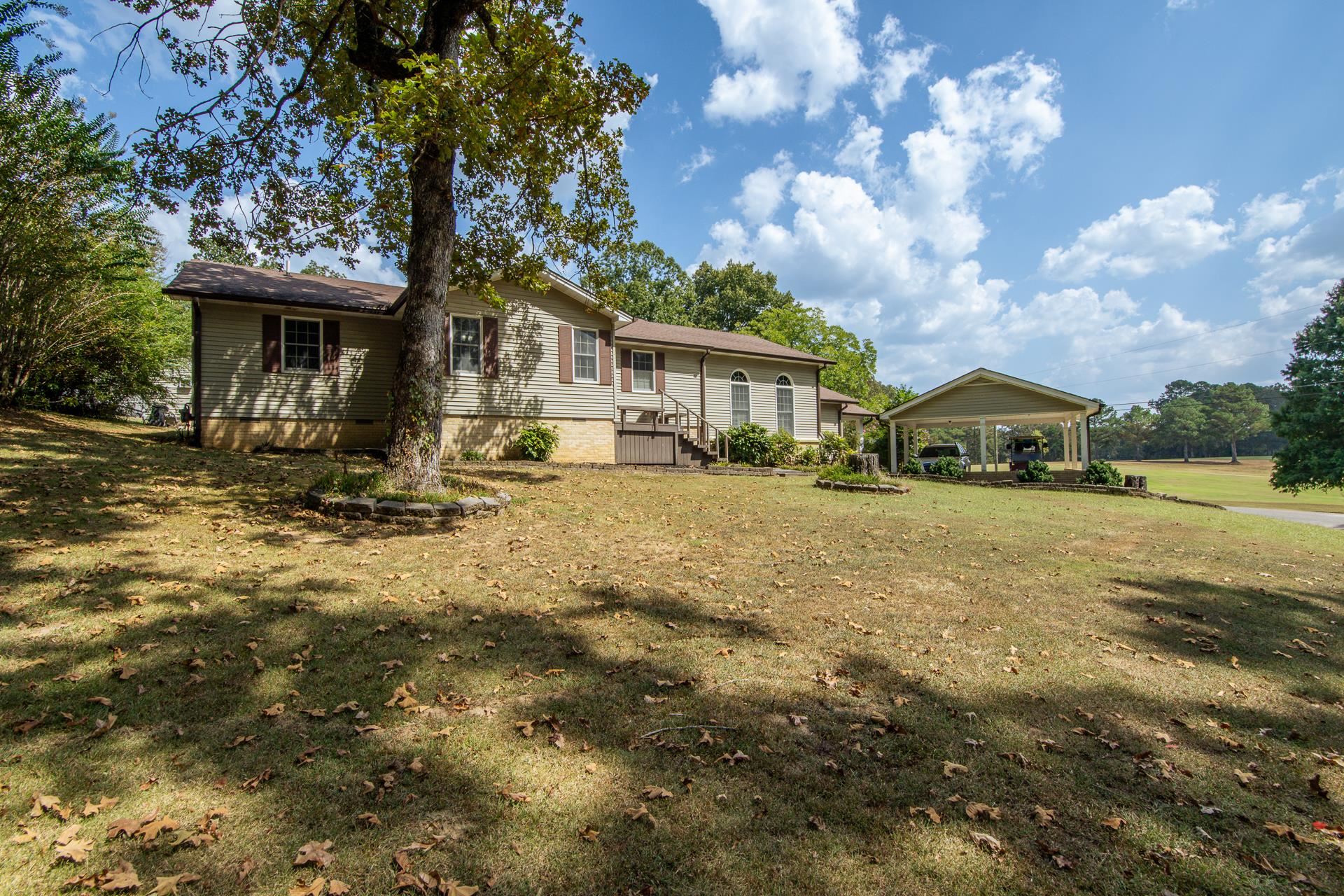 313 Country Club Lane Selmer, TN 38375 - Photo 4 of 36 a yellow house with trees in front of it