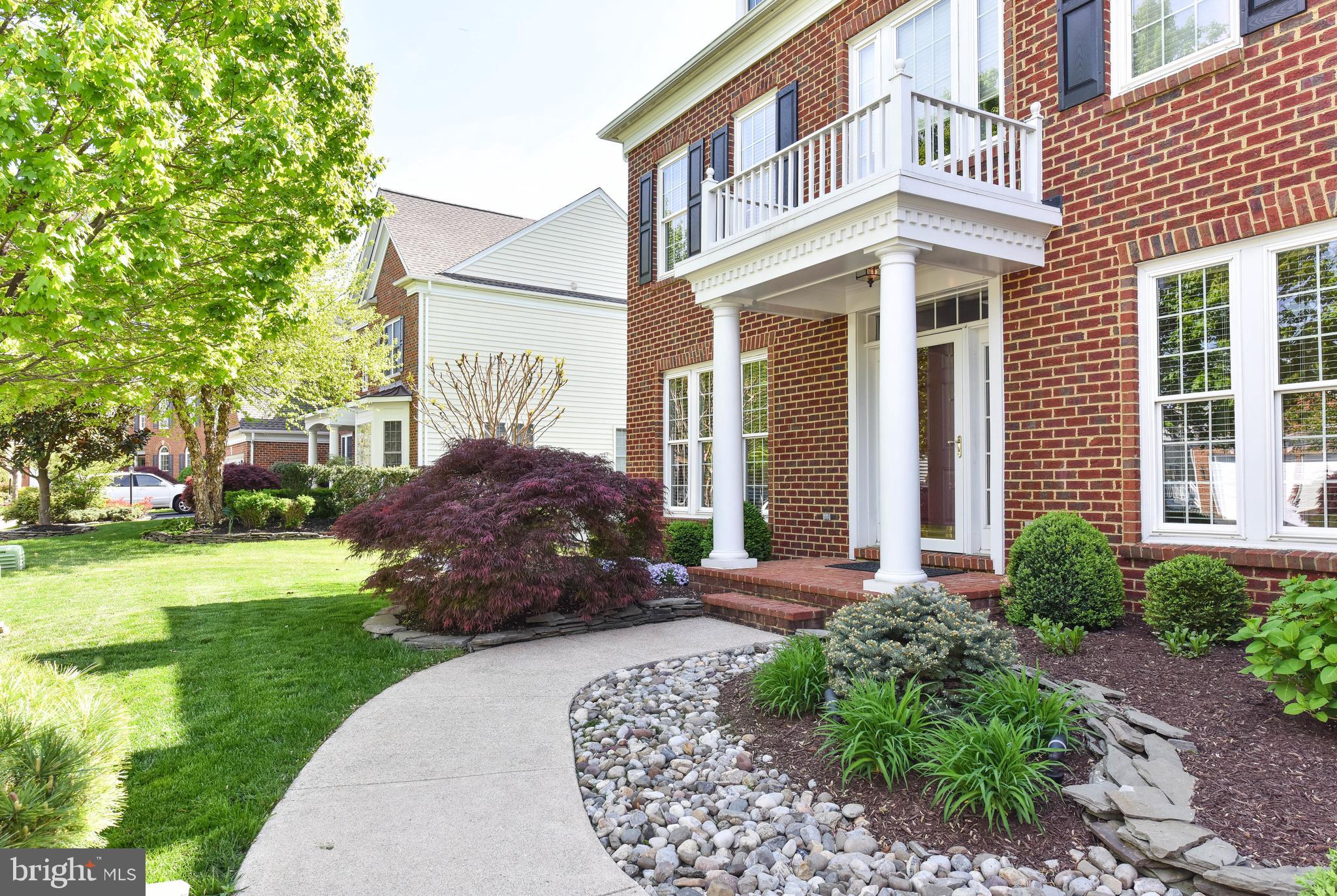 8244 Native Violet Drive Lorton, VA 22079 - Photo 2 of 68 a front view of a house with a garden and plants