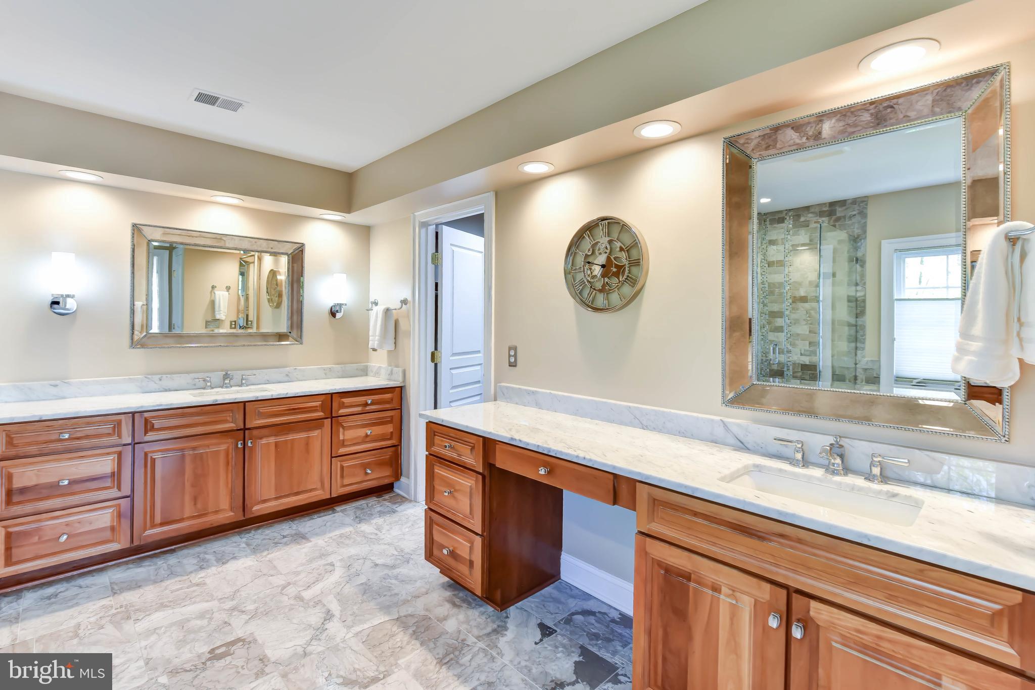 8244 Native Violet Drive Lorton, VA 22079 - Photo 8 of 68 a spacious bathroom with a granite countertop sink and a large mirror