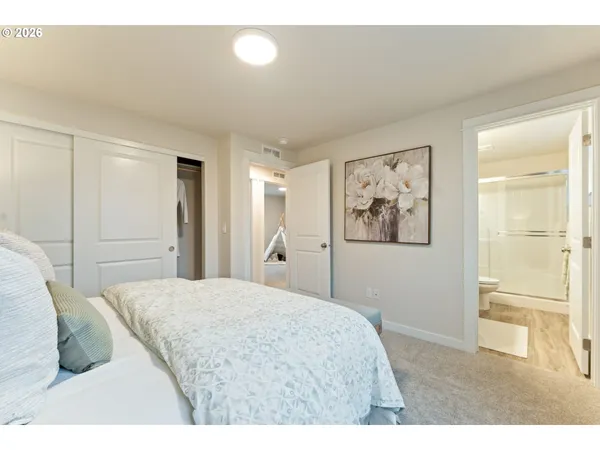 a bedroom with a bed and a painting on the wall