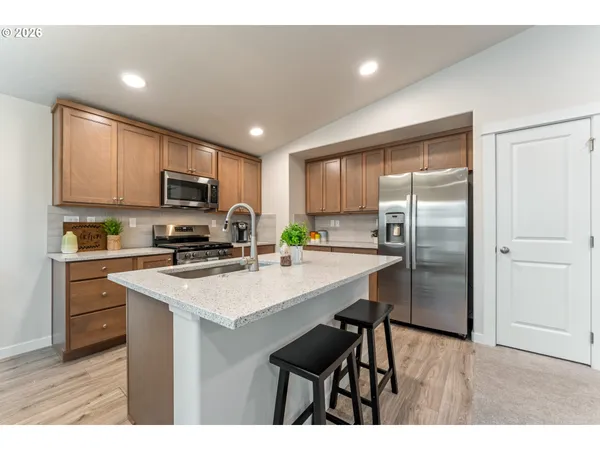 a kitchen with kitchen island a refrigerator stove microwave and cabinets