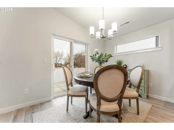 a dining room with furniture a chandelier and wooden floor
