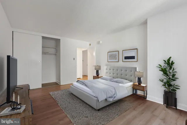 a bedroom with a bed and a potted plant