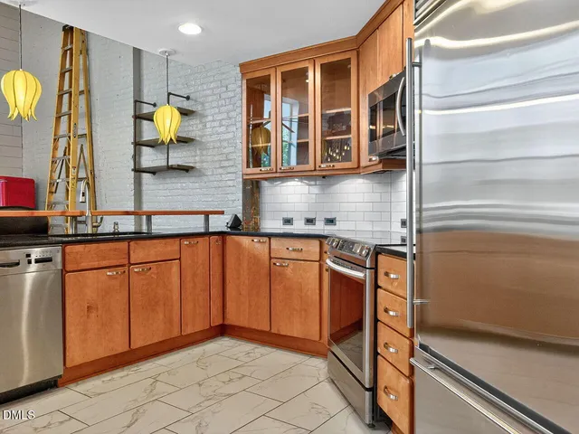 a kitchen with stainless steel appliances granite countertop a stove and cabinets
