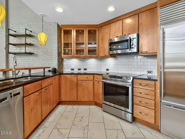 a kitchen with a sink and a large mirror next to a window