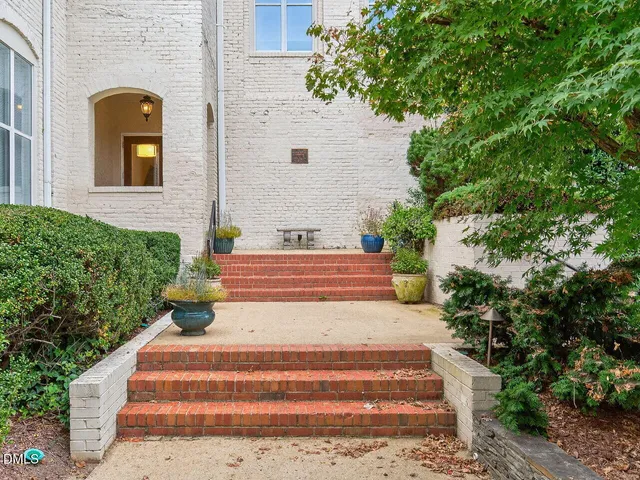 a front view of a house with plants and trees