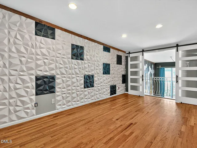 a view of empty room with wooden floor and fireplace