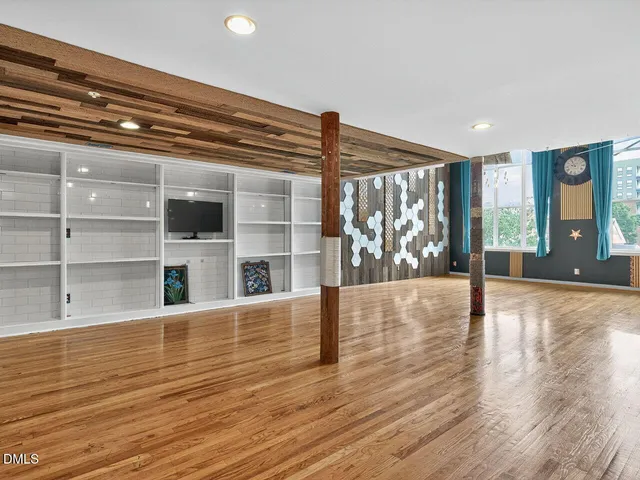 a view of a living room with wooden floor and large window