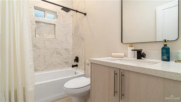 a bathroom with a granite countertop sink a toilet and a bathtub
