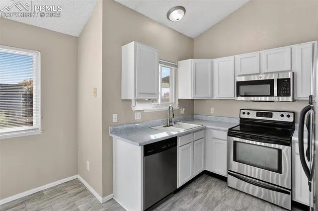 a open kitchen with cabinets and stainless steel appliances