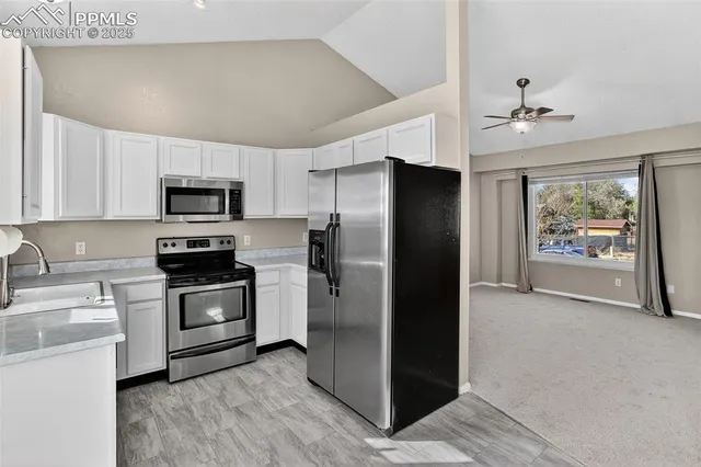 a kitchen with appliances a sink and cabinets
