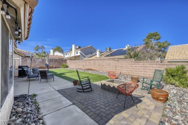 1536 Pony Ranch Circle Henderson, NV 89014 - Photo 20 of 23 Fenced backyard featuring a patio area, grilling area, and an outdoor fire pit