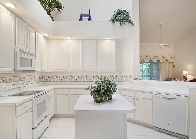 a kitchen with white cabinets and sink