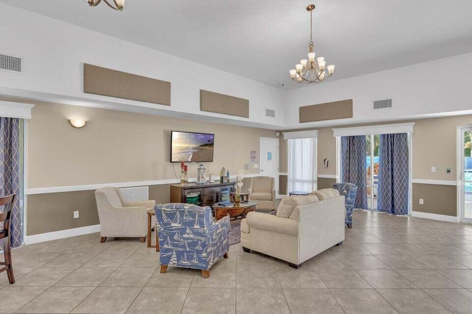 1639 Southwest Harbour Isles Circle, Unit 29 Port St. Lucie, FL 34986 - Photo 27 of 35 a living room with furniture and a chandelier