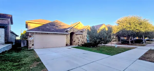 a view of a house with a yard and table and chair under an umbrella