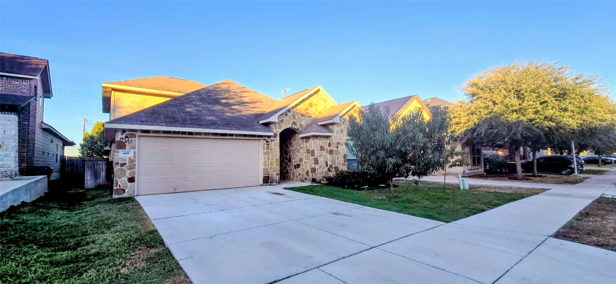 a view of a house with a yard and table and chair under an umbrella