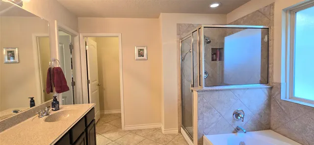 a bathroom with a granite countertop sink a mirror and a shower