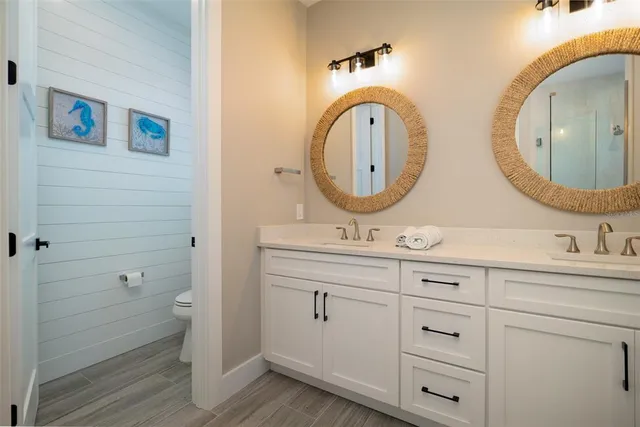 a bathroom with a toilet a sink a vanity and mirror