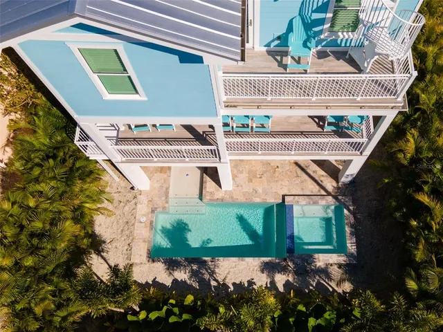 an aerial view of a city with lots of residential buildings and ocean view in back