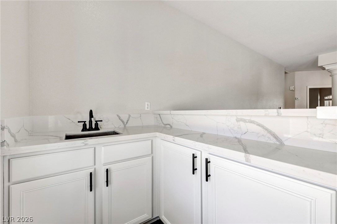 740 Aldo Rae Court, Unit NONE Henderson, NV 89052 - Photo 16 of 35 A well-appointed wet bar offers ample storage, a built-in sink, and luxurious marble countertops.