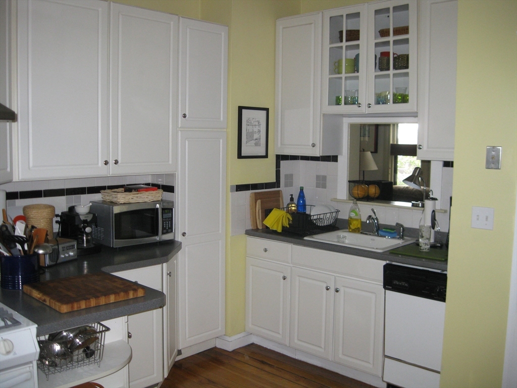 123 Cushing Avenue, Unit 1 Boston, MA 02125 - Photo 11 of 16 a kitchen with stainless steel appliances granite countertop a stove a sink and a microwave
