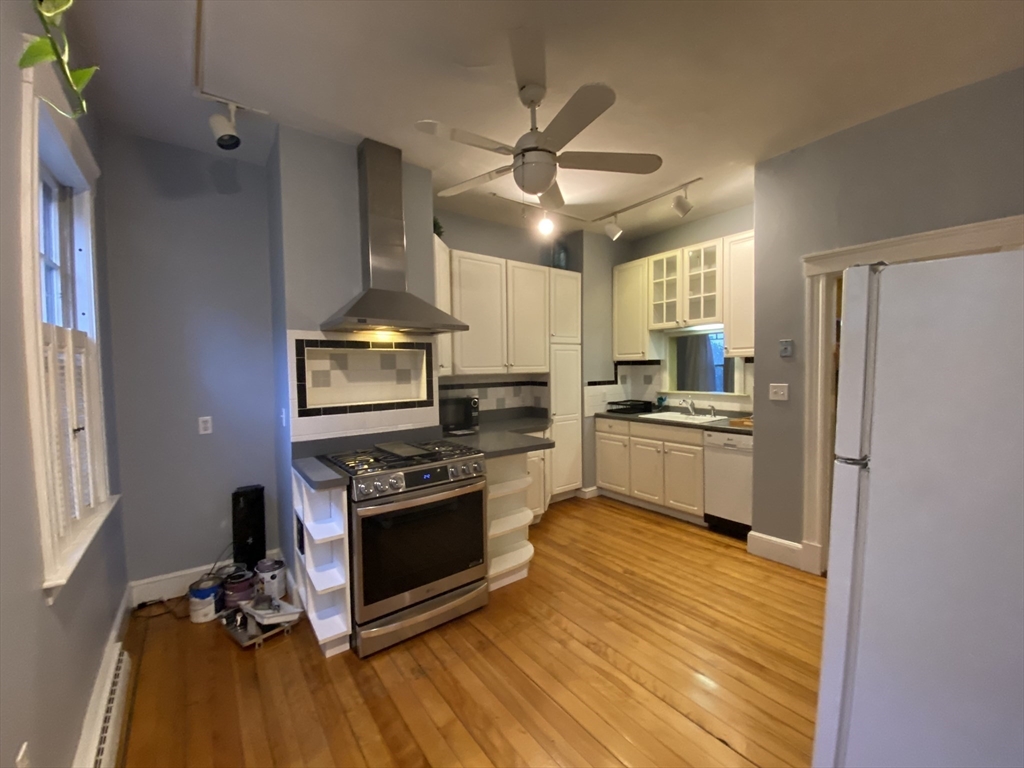 123 Cushing Avenue, Unit 1 Boston, MA 02125 - Photo 13 of 16 a kitchen with a stove a refrigerator and a fireplace