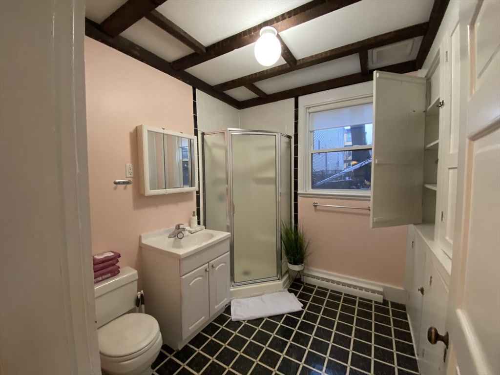 123 Cushing Avenue, Unit 1 Boston, MA 02125 - Photo 15 of 16 a bathroom with a sink toilet and shower