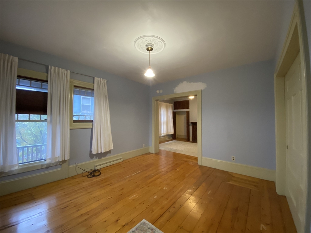 123 Cushing Avenue, Unit 1 Boston, MA 02125 - Photo 9 of 16 a view of an empty room with window and wooden floor