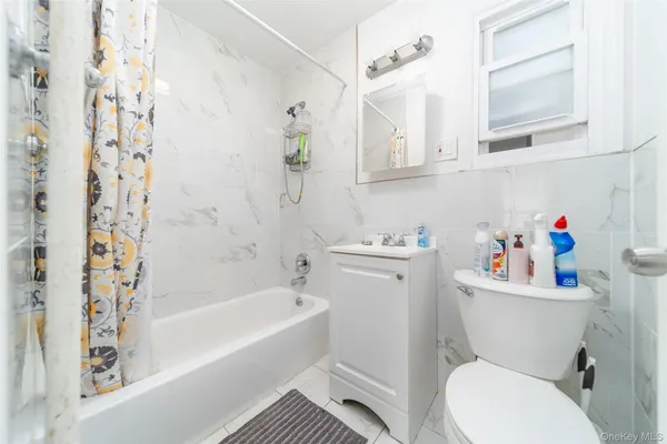 a white toilet sitting next to a bathroom sink and tub