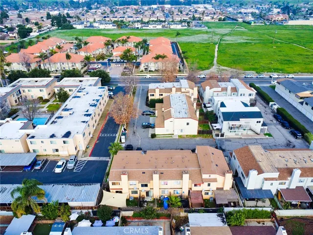 an aerial view of a city with lots of residential buildings and ocean view in back