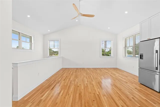 a view of empty room with wooden floor and window