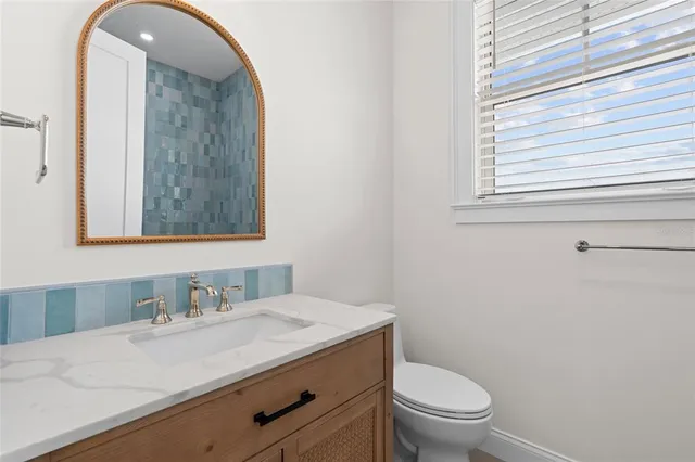a bathroom with a granite countertop sink a toilet and a mirror