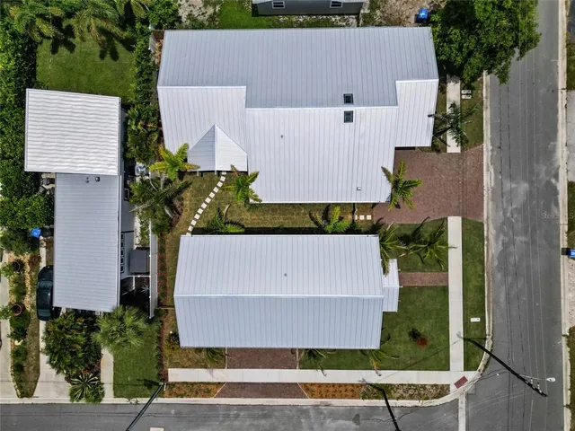 an aerial view of a house with a yard and large tree