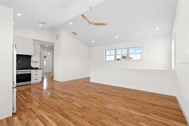 wooden floor in an empty room with a kitchen