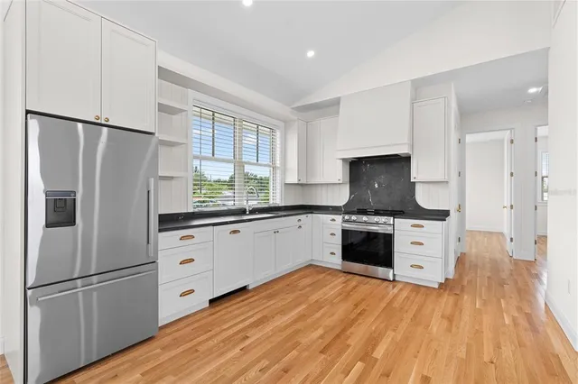a kitchen with stainless steel appliances a refrigerator sink and cabinets
