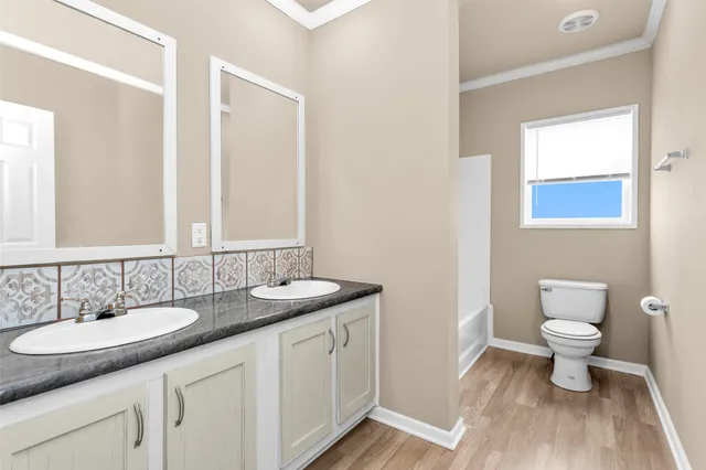 a bathroom with a granite countertop sink a toilet and a mirror