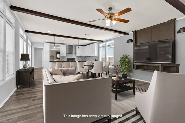 a living room with furniture a flat screen tv and kitchen view