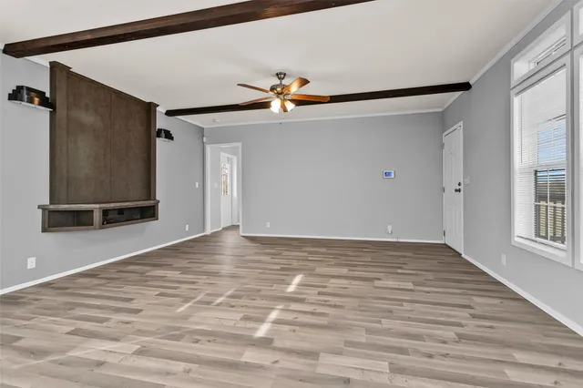 a view of a hallway with wooden floor and chandelier