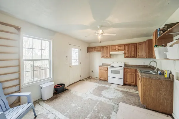 a kitchen with a stove a sink a refrigerator and cabinets