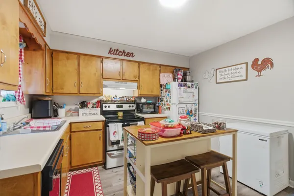 a very nice looking open kitchen with a table and chairs in it