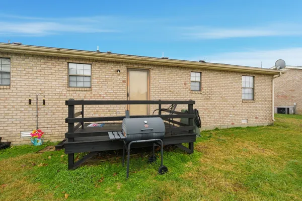a view of a lake with lawn chairs and large trees