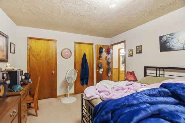 a bed room with a bed and a painting on the wall