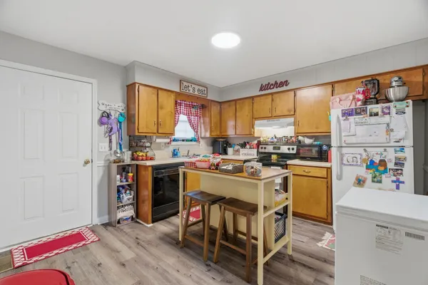 a view of kitchen with stainless steel appliances granite countertop a stove and a refrigerator