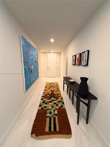 a view of a hallway to a livingroom with furniture and staircase